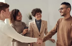Group of young employees shaking hands